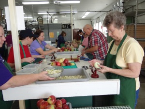 4-H volunteers peel and prepare apples. 