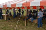 Participants listen at a session under a tent outdoors.